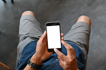 Closeup man hands holding smart phone with blank copy space screen for your text message or information content, male reading text message on cell telephone during in urban setting.