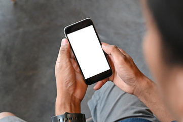 Closeup man hands holding smart phone with blank copy space screen for your text message or information content, male reading text message on cell telephone during in urban setting.