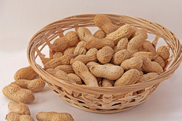Peanuts in a wicker basket on a white background