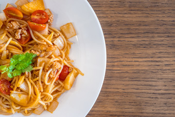 Plate of delicious Italian spaghetti with tomato sauce on wooden table background with copy space