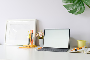 Workspace mockup tablet and office supplies on office desk.