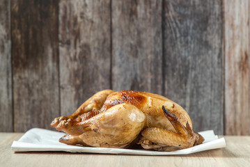 Roasted chicken on light table. Side view