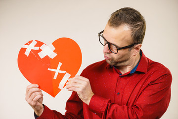 Adult man holding broken heart