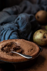 Chocolate cake and pears, towel. Dark background, rustic.