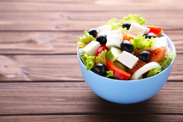 Fresh vegetable salad on brown wooden background