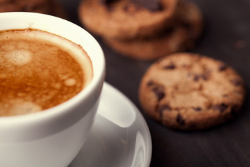 Coffee cup with chocolate cookies on dark old wooden table. Breackfast