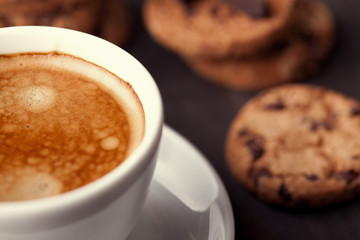 Coffee cup with chocolate cookies on dark old wooden table. Breackfast
