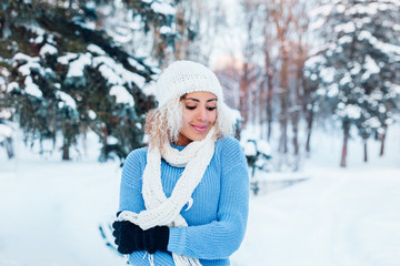 Fototapeta na wymiar Happy winter moments of joyful young woman with afro hair, white winter clothes having fun on street in snowing time. Expressing positivity, true brightful emotions