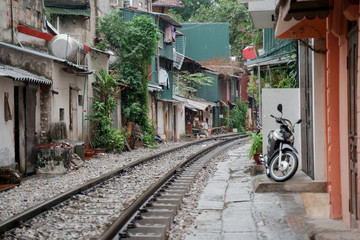 Fototapeta na wymiar Hanoi Train Street. Vietnam city railway at rainy day. Famous tourist destination
