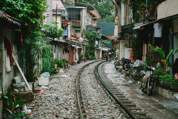 Fototapeta na wymiar Hanoi Train Street. Vietnam city railway at rainy day. Famous tourist destination