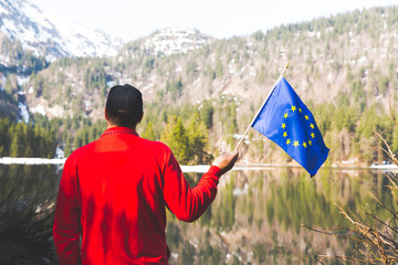 hiker with red sweater and flag from the european union outdoor somewhere in the austrian alps