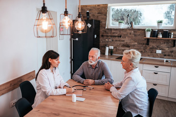 Female doctor discussing with senior couple.