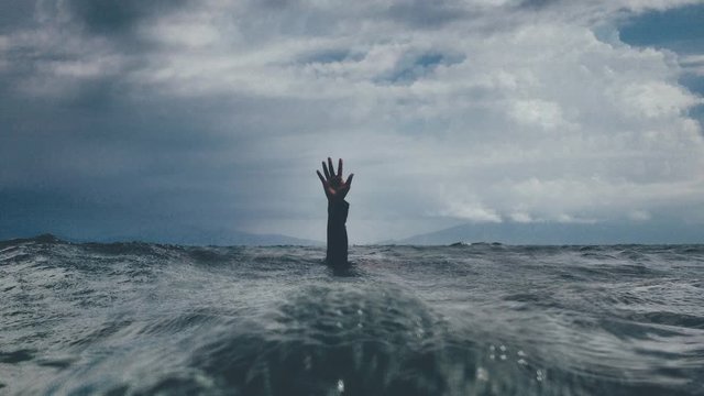 Cinemagraph of desperate man seeking help sinking in the ocean