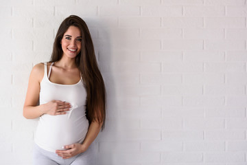 Fototapeta premium Portrait of happy smiling beautiful pregnant woman at home. Mother-to-be