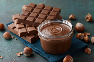 Chocolate spread with hazelnuts on blue green countertop