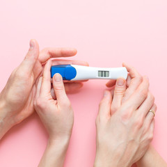 Wife and husband holding in hands pregnancy test