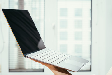 Young freelancer is holding up a thin elegant notebook