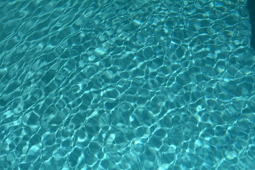 Fototapeta na wymiar Textured water of a clean swimming pool makes an ideal background for summer living.