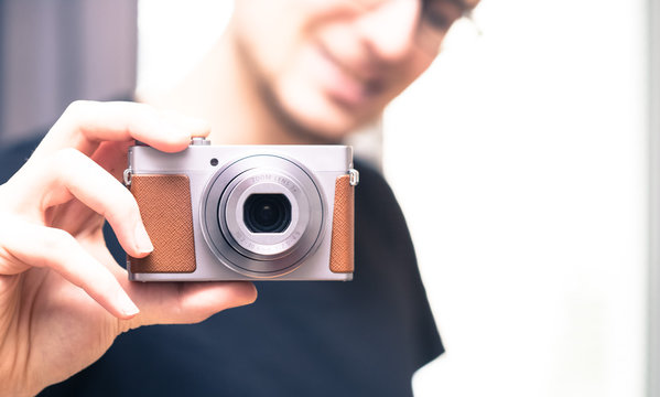 Young man takes a picture with a retro camera