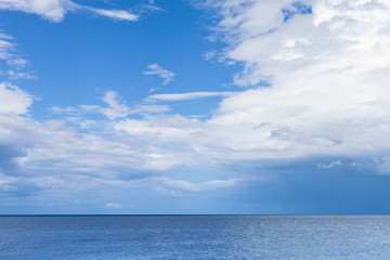 Naklejka na ściany i meble Seascape with blue water under cloudy sky