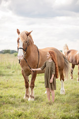 Fototapeta premium girl with brown horse in the field