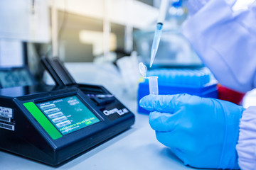 Instruments and scientific equipment. Scientists are using a micropipette to suck the solution for...