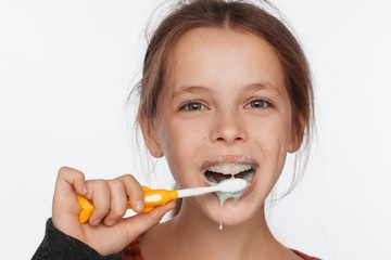 Portrait of an eight-year-old girl who brushes her teeth with a toothbrush