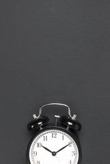 Black retro alarm clock on gray dark background top view Flat lay copy space. Minimalistic background, concept of time, deadline, time to work, morning