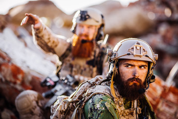 rangers with assault rifles on battlefield background. army, military and people concep