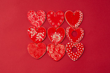 Red decorative hearts over red background. Valentine's Day, love celebration. Copy space. Top view.
