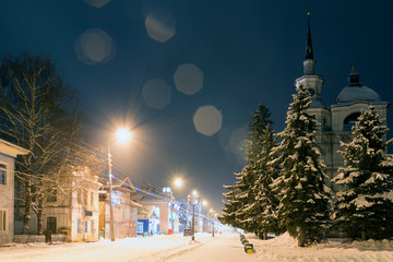 Night winter view of the Sovetsky prospect and Cathedral of the Assumption (Uspensky Sobor) behind the snow-covered firs. Veliky Ustyug, Vologda Region, Russia.