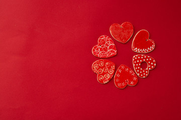 Fototapeta premium Red decorative hearts over red background. Valentine's Day, love celebration. Copy space. Top view.