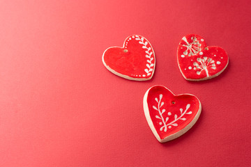 Fototapeta premium Red decorative hearts over red background. Valentine's Day, love celebration. Copy space. Top view.