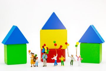 Miniature people: family and children enjoy with colorful balloons, wooden block, happy family day concept.