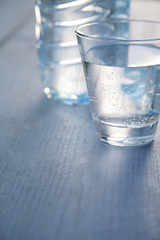 a glass and a bottle of mineral water