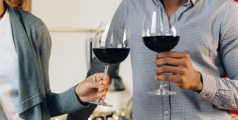 Happy couple celebrating and cheering with glasses of wine