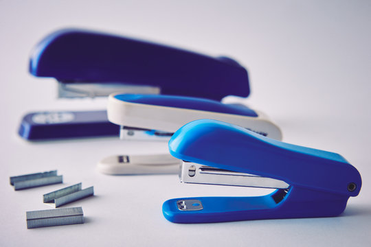 Three staplers on a white background, close-up