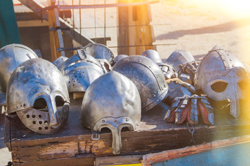 many helmets of an old knight in the sunlight outdoors in summer