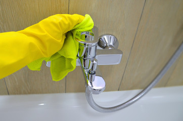 Woman doing chores in bathroom, cleaning of water tap. Image.
