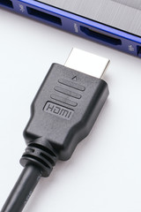 HDMI cable near the HDMI port of the modern blue laptop on a white background. Horizontal shot