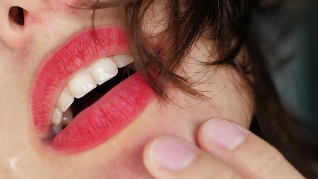 Close up girl touches her lips with her hands in a fit of passion