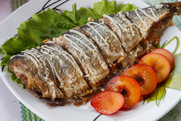 Baked mackerel with green lettuce and fruit. Close-up