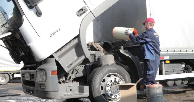 Truck Service.Mechanic repairing truck. Air filter. Change of oil.