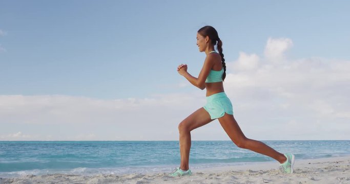 Fitness woman doing Pulse Lunges exercise. Female fitness model doing Lunge Pulses workout while exercising on beach working out glutes, hamstrings and quadriceps.