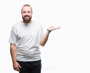 Young caucasian hipster man wearing casual t-shirt over isolated background smiling cheerful presenting and pointing with palm of hand looking at the camera.