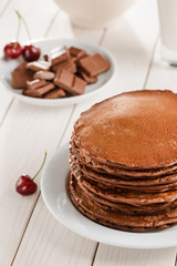 Brown pancakes, chocolate and cherries