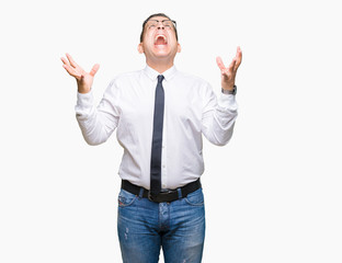 Middle age bussines arab man wearing glasses over isolated background crazy and mad shouting and yelling with aggressive expression and arms raised. Frustration concept.