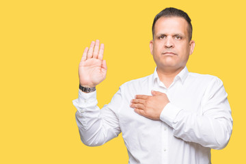 Middle age arab elegant man over isolated background Swearing with hand on chest and open palm,...