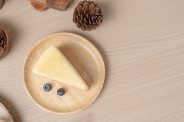 Fototapeta na wymiar Homemade Cheese cake or butter cake put on wooden plate or dish with blueberry and place on table.