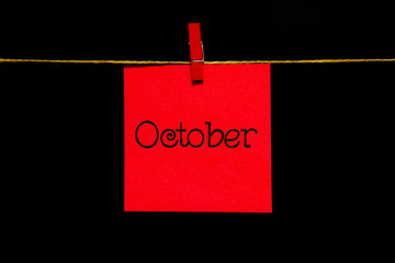Copy space. Month of the year. Red sticker. On the sheet inscription October. The sheet is attached...